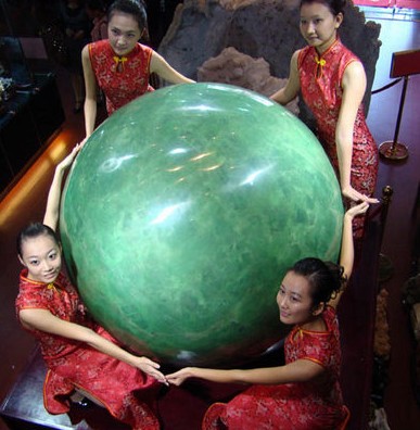 11月21日,一顆重達6噸,直徑1.6米,業(yè)內(nèi)估計價值22億人民幣的夜明珠,在海南僑文昌寶玉宮展出。圖為模特擁抱夜明珠。