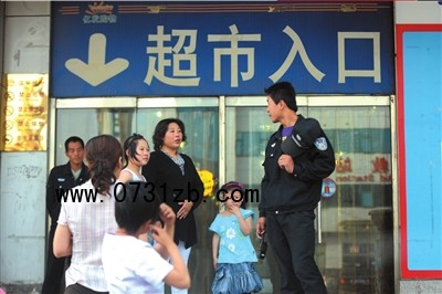 治安隊(duì)員把守大門，阻止顧客進(jìn)入商場(chǎng)。本報(bào)記者潘之望攝